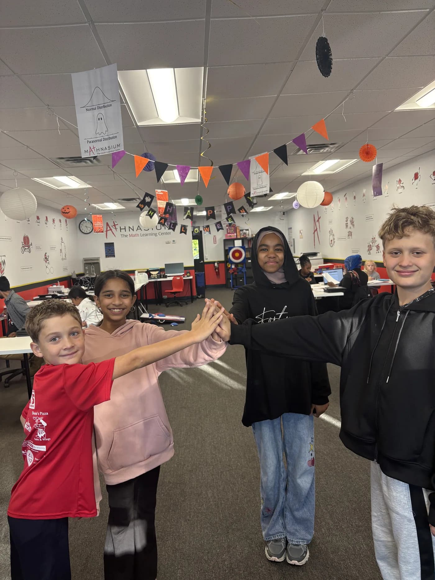 Students sharing a group high five at Mathnasium of Loudonville