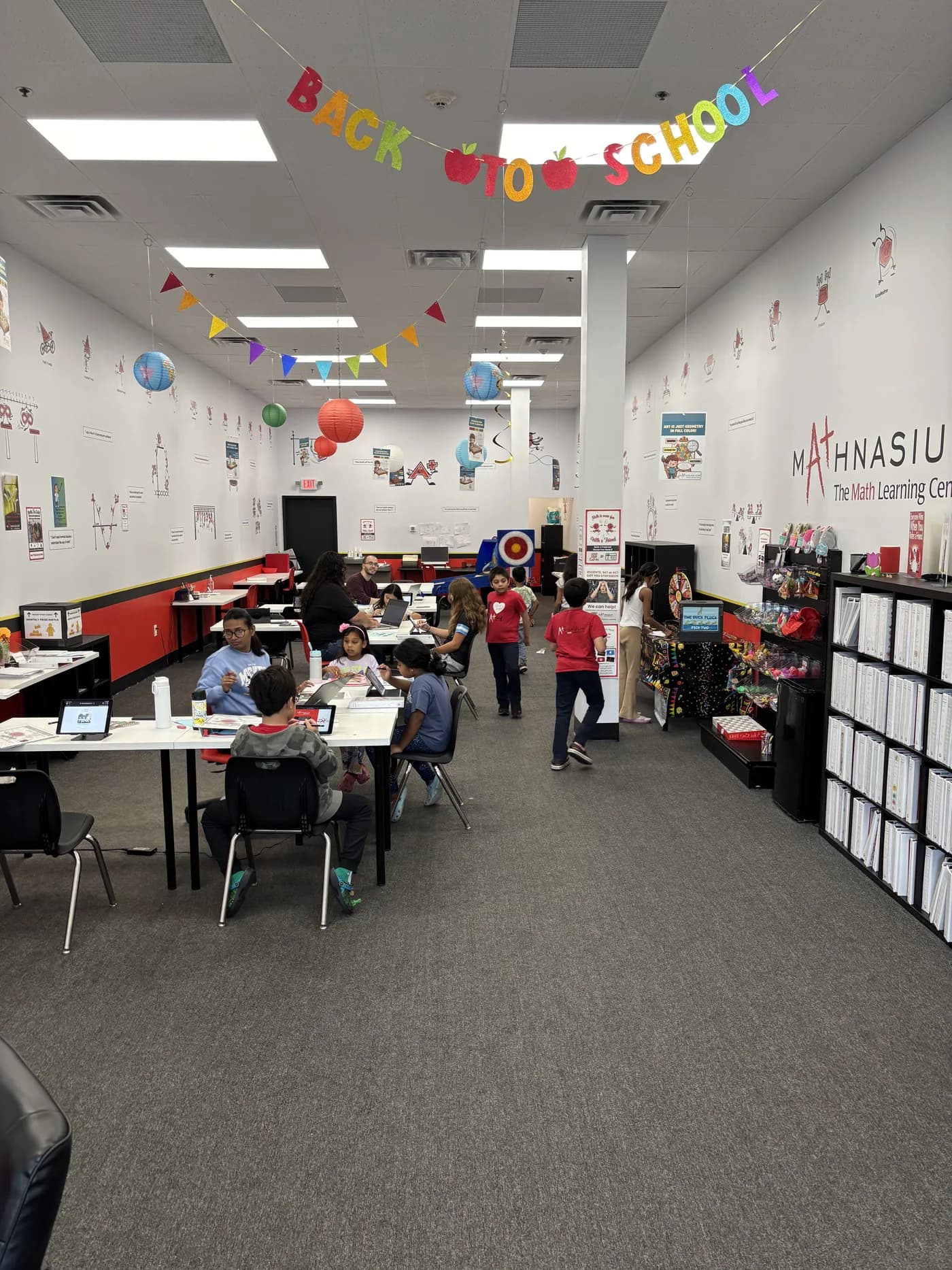 Students and instructors at work tables inside Mathnasium of Niskayuna